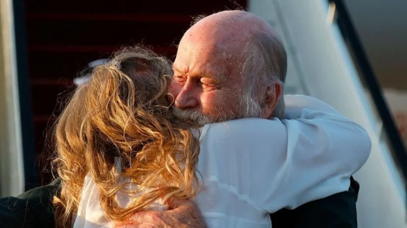 Peter Reynolds memeluk putrinya, Sarah Entwistle, sesaat setelah mendarat di Doha, Qatar. Ia dan istrinya, Barbie Reynolds, dibebaskan setelah ditahan Taliban selama hampir delapan bulan. (Sumber: AFP via Getty Images)