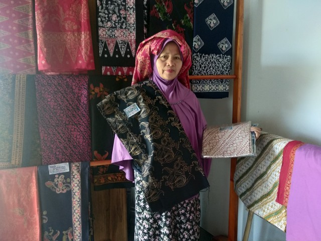 Pemilik Rumah Batik Putri bersama kain batik koleksinya. Foto: Yovy Hasendra