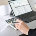 Asian woman entering journal entries in accounting software